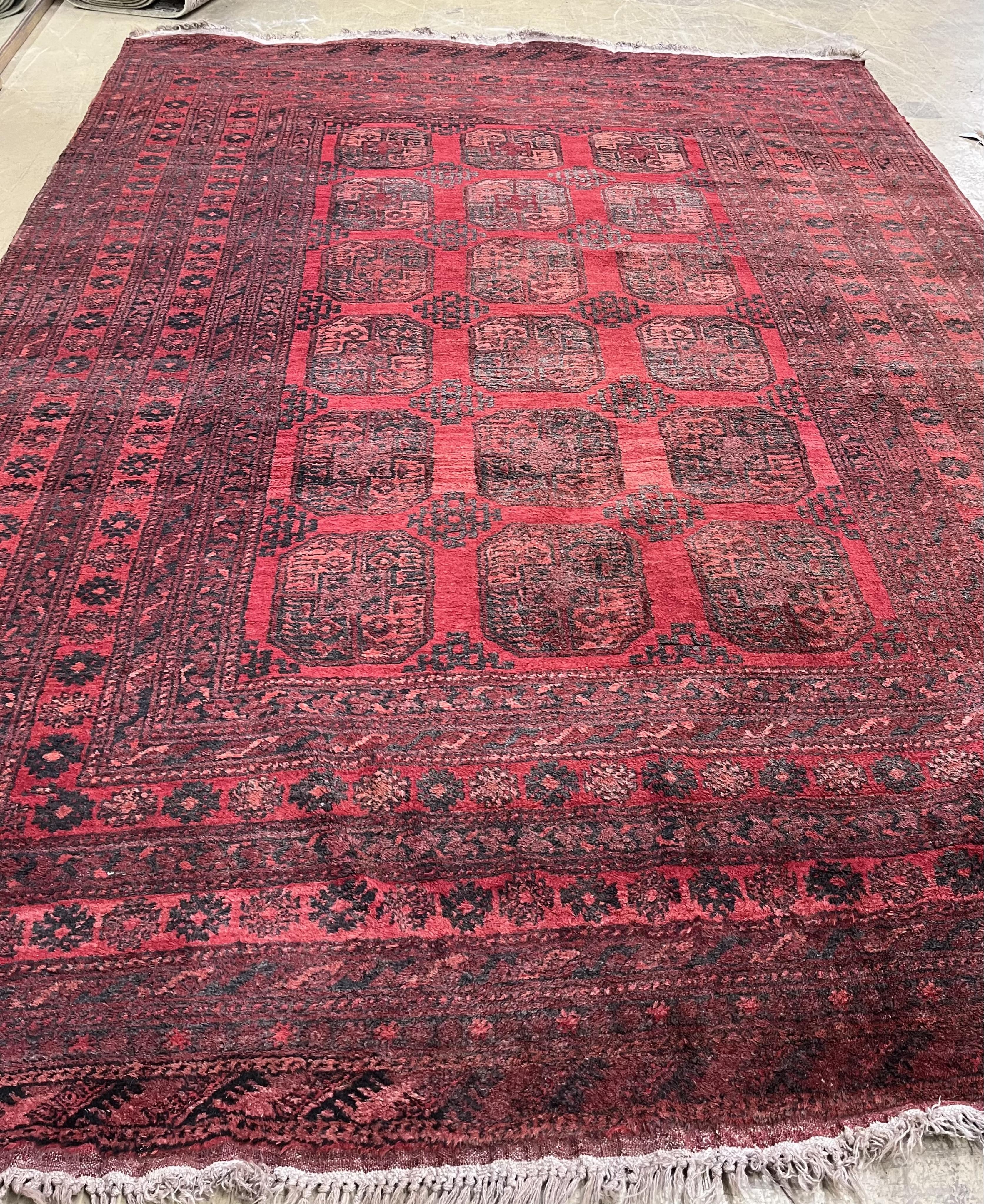 An Afghan red ground carpet, 330 x 240cm. Condition - fair